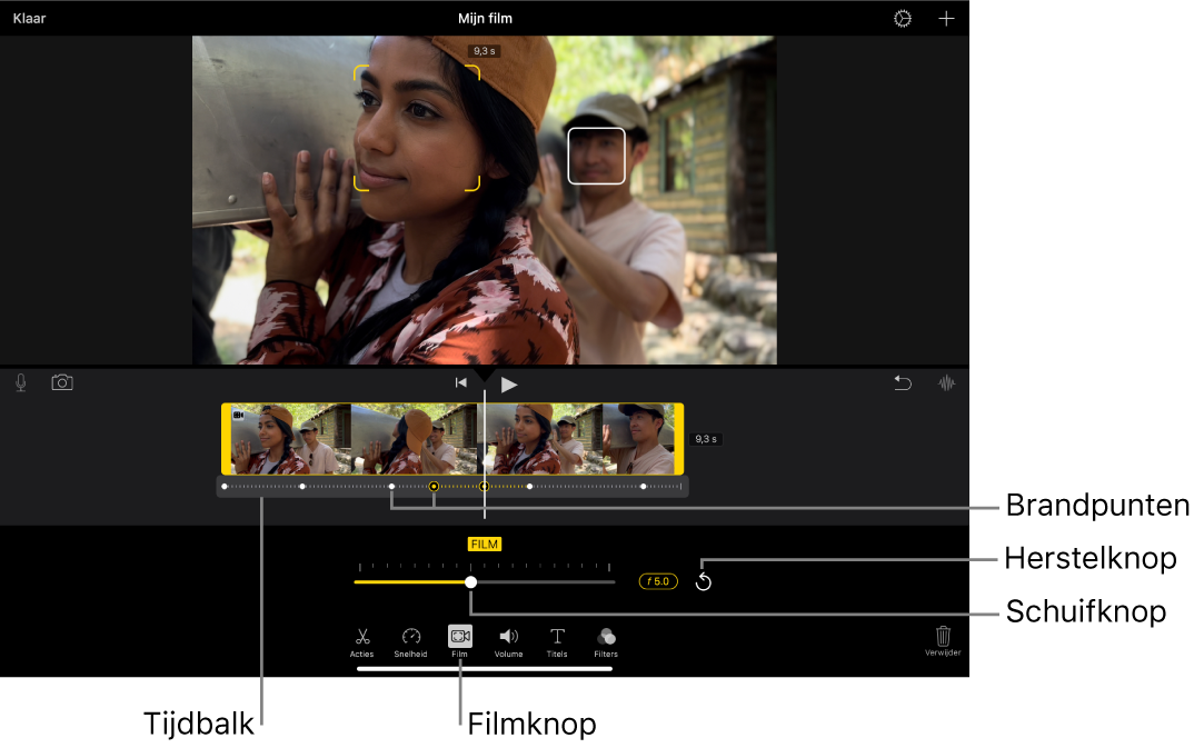 Een videofragment in de Film-modus in het weergavevenster, met gele vierkante haken rond het object waarop is scherpgesteld en een wit kader rond een object waarop niet is scherpgesteld. In de tijdbalk staan witte en gele brandpunten.