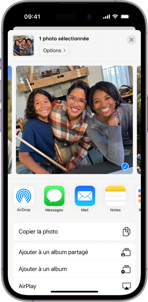 Une photo sélectionnée est affichée dans la moitié supérieure de l’écran de l’iPhone, avec des options de partage en dessous : AirDrop, Messages, Mail et Notes. Sous ces options de partage se trouvent d’autres actions que vous pouvez effectuer sur la photo, notamment Copier la photo, Ajouter à un album partagé, Ajouter à un album et AirPlay.