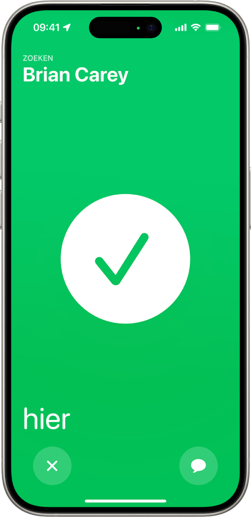 Het iPhone-scherm is groen met in het midden een grote vink. De naam van de gezochte persoon staat linksbovenin en het woord "hier" staat linksonderin om aan te geven dat de ontmoeting gelukt is.