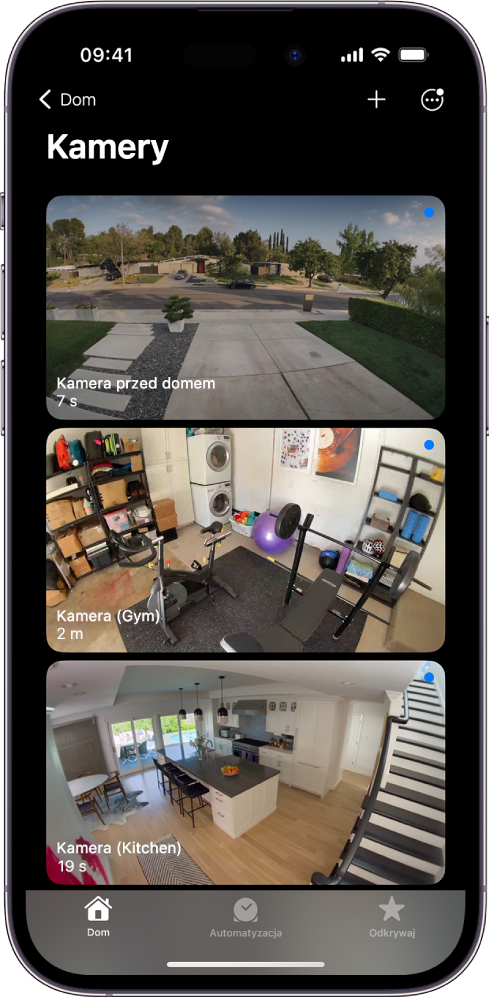 Ekran Kamery, wyświetlający obraz z trzech kamer monitoringu: Przed domem, Siłownia oraz Kuchnia. Pod nazwą każdej kamery widoczny jest czas, który upłynął od ostatniego odświeżenia obrazu. Na przykład, kamera przed domem pokazuje, że obraz został ostatnio odświeżony siedem sekund temu.