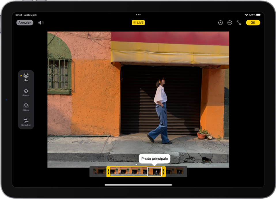 Une Live Photo se trouve au centre de l’écran Modifier dans l’app Photos. Le visualiseur d’image se trouve en bas de la vidéo et un contour jaune entoure les images sélectionnées à inclure dans la Live Photo modifiée ; une seule image est sélectionnée pour créer la photo principale. Les outils de modifications se trouvent sur le côté gauche de l’écran, avec de haut en bas : « Live Photo », Ajuster, Filtres et Recadrer. « Live Photo » est sélectionné.