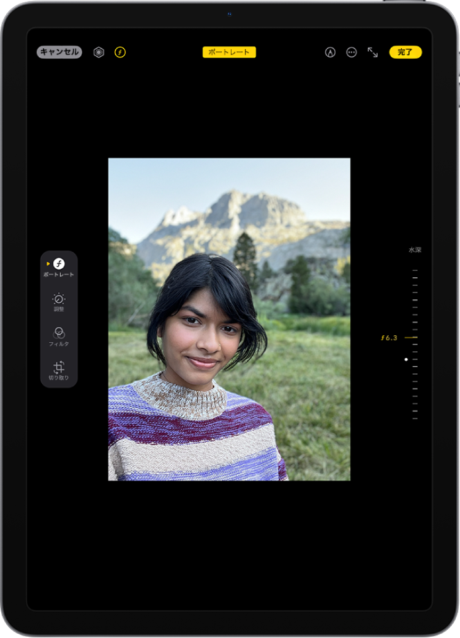 ポートレートモードの写真の「編集」画面。画面の中央にポートレート写真があります。画面の右側には、被写界深度の設定を調整するスライダがあります。画面の左側には、「ポートレート」、「調整」、「フィルタ」、および「切り取り」の各ボタンがあります。「ポートレート」ボタンが選択されています。