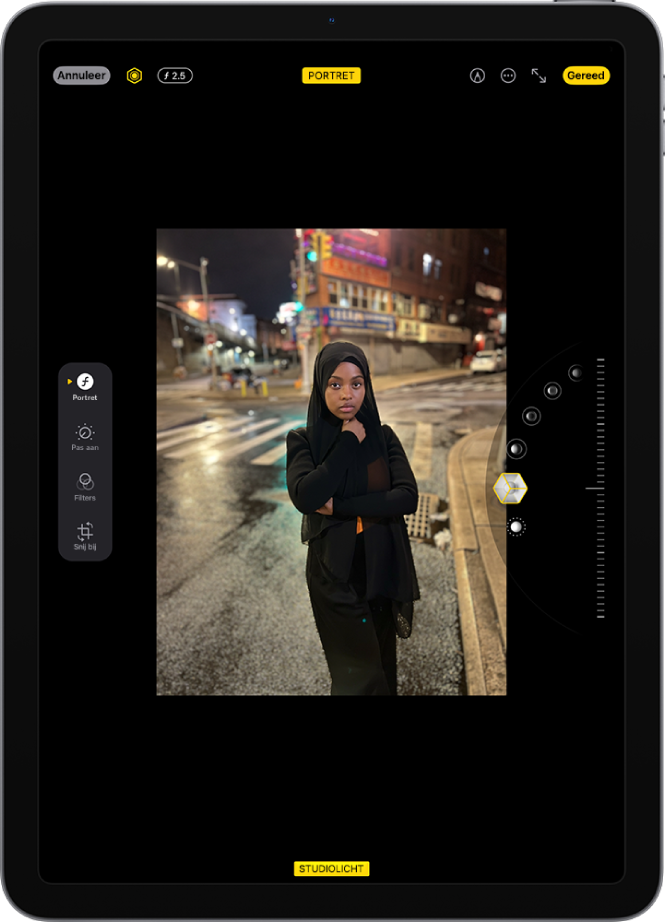 Het bewerkingsscherm van een foto in de portretmodus. De foto staat in het midden van het scherm en aan de rechterkant van het scherm staan de opties voor het portretbelichtingseffect. 'Studiolicht' is geselecteerd en er is een schuifknop om de intensiteit van het effect aan te passen. Aan de linkerkant van het scherm staan de knoppen 'Portret', 'Pas aan', 'Filters' en 'Snij bij'. De knop 'Portret' is geselecteerd.