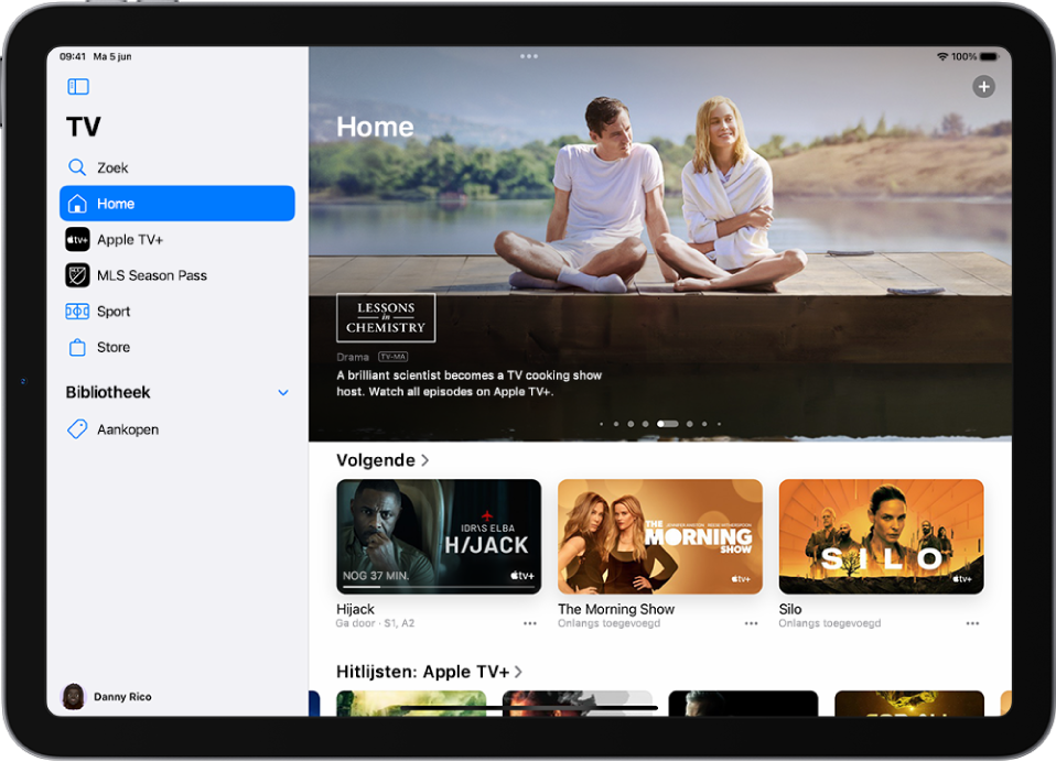 Het scherm 'Home' met in het midden een uitgelichte Apple Original, boven de rijen 'Volgende' en 'Nu populair: Apple TV+'. Aan de linkerkant staan van boven naar beneden de tabs 'Zoek', 'Home', 'Apple TV+', 'MLS Season Pass', 'Sport' en 'Store'.