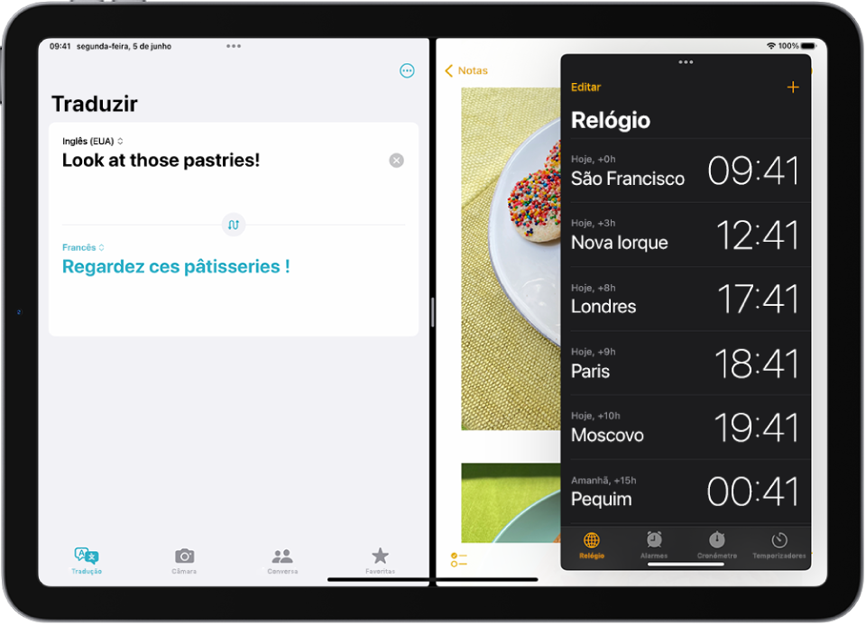 A aplicação Traduzir está aberta no lado esquerdo do ecrã, a aplicação Notas está aberta à direita e a aplicação Relógio está aberta numa janela Slide Over que tapa parcialmente a aplicação Notas.
