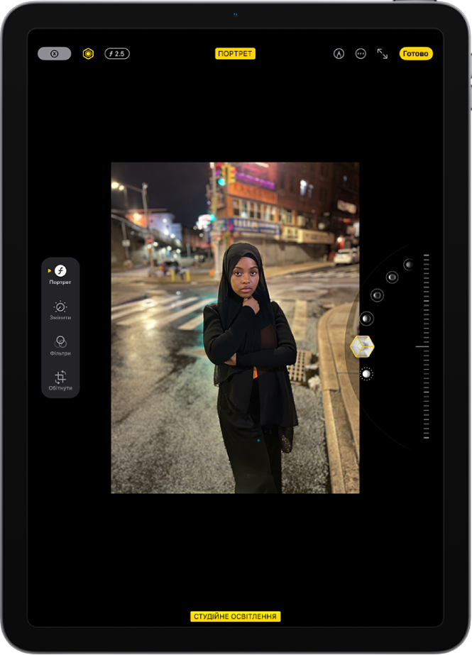 Екран «Змінити» для фотографії в режимі «Портрет». У центрі екрана — фотографія, а в правій частині — опції ефекту портретного освітлення. Вибрано «Студійне світло» і передбачено повзунок призначений для корекції рівня ефекту. З лівого боку екрана розташовані кнопки «Портрет», «Корекція», «Фільтри» й «Кадрування». Вибрано кнопку «Портрет».