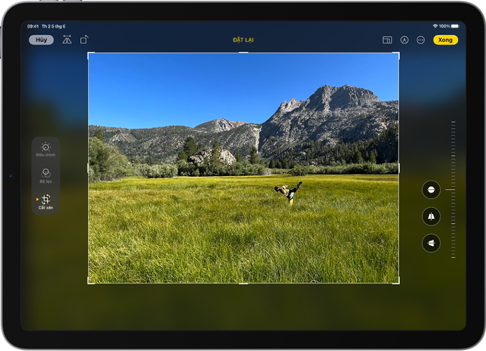 Màn hình Sửa trong ứng dụng Ảnh với một ảnh ở chính giữa. Ở bên trái của màn hình là các nút Điều chỉnh, Bộ lọc và Cắt xén; nút Cắt xén được chọn. Ở bên phải của màn hình là các tùy chọn cải thiện cắt xén và một thanh trượt để điều chỉnh mức độ của hiệu ứng.