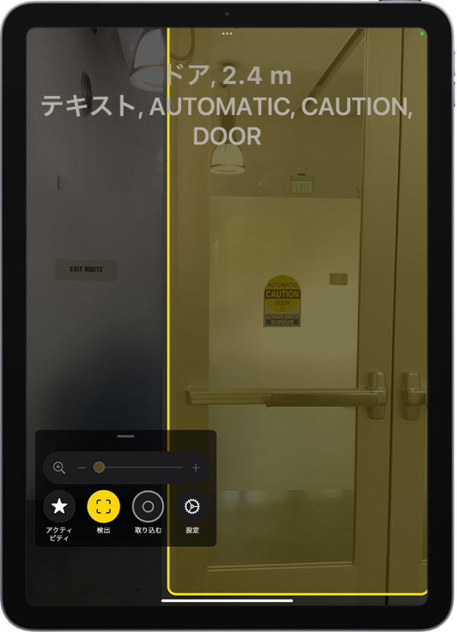拡大鏡アプリが開いていて、ドアの検出が進行中です。説明には、ドアまでの距離と、ドアに書かれているテキストの内容が示されています。
