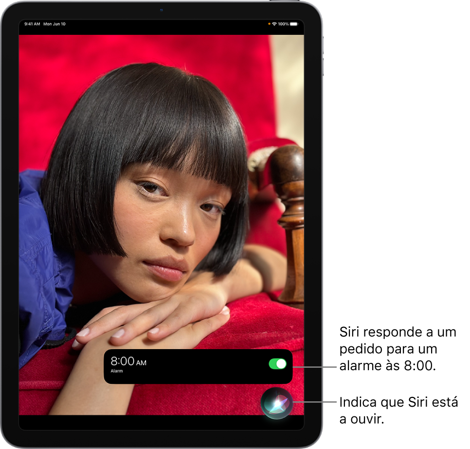 O ecrã de um iPad. Junto à parte inferior do ecrã, uma notificação da aplicação Relógio mostra que um alarme está ativado para as 8:00. Um ícone por baixo da notificação indica que Siri está a ouvir.