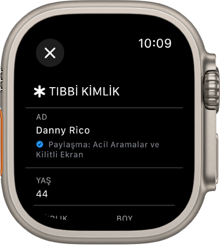 Apple Watch’taki Tıbbi Kimlik ekranı kullanıcının adını ve yaşını gösteriyor. Adın altında bir onay işareti var, Tıbbi Kimlik’in kilitli ekranda paylaşıldığını gösteriyor. Kapat düğmesi sol üstte.