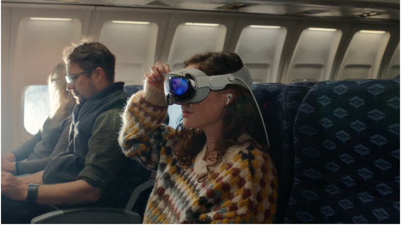 女性佩戴 Apple Vision Pro，耳中戴有 AirPods Pro。