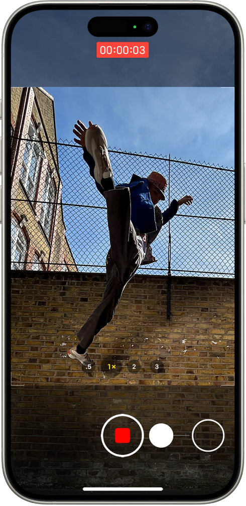 The Camera screen in Photo mode. The subject fills the center of the screen, inside the camera frame. At the bottom of the screen, the Shutter button moves to the right, demonstrating the movement of starting a QuickTake video. The video timer is at the top of the screen.