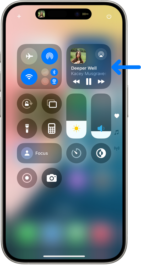 El centro de control del iPhone mostrando una flecha apuntando a la tarjeta de audio donde puedes controlar la música desde la pantalla bloqueada o al usar otra app.