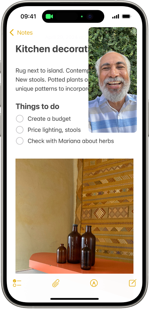 Une conversation FaceTime en cours, avec tout le reste de l’écran occupé par une note relative à la décoration d’une cuisine.