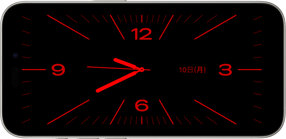 スタンバイモードのiPhone。周囲が薄暗いため、時計ウィジェットとカレンダーウィジェットが赤みがかった色で表示されています。