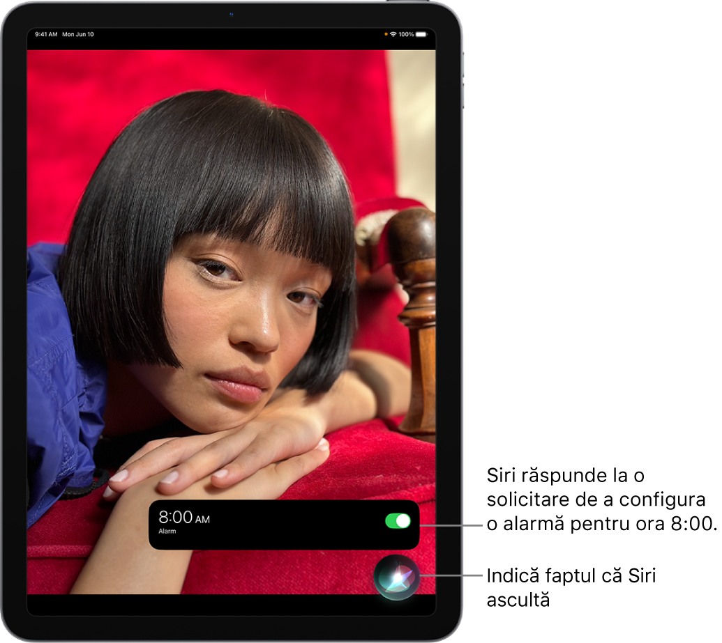 Ecranul unui iPad. În apropierea părții de jos a ecranului, o notificare de la aplicația Ceas arată că o alarmă este activată pentru ora 8:00. O pictogramă de sub notificare indică faptul că Siri ascultă.