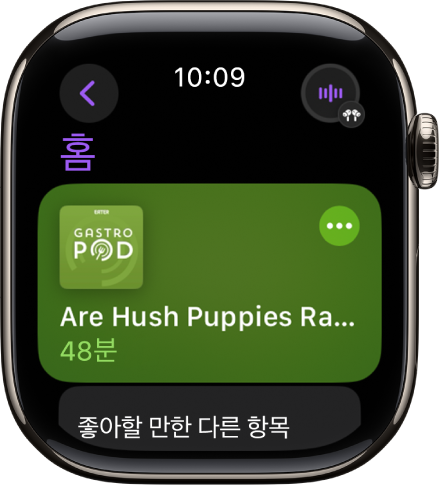 Apple Watch의 팟캐스트 앱에 팟캐스트 표지와 함께 홈 화면이 표시됨. 에피소드를 재생하려면 해당 작품을 탭함.