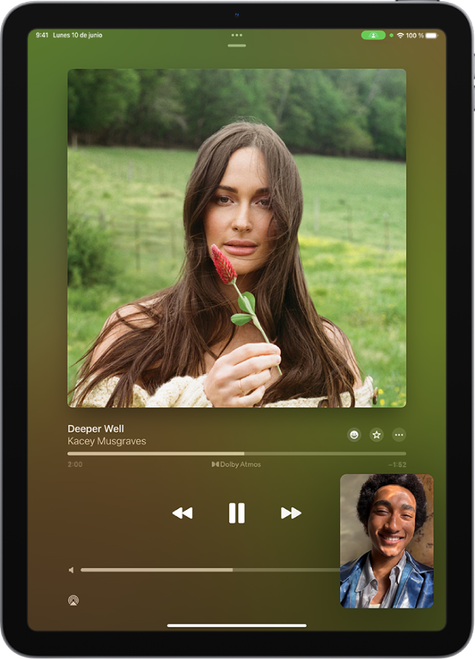 Una llamada de FaceTime con una sesión de SharePlay, con contenido de Apple Music compartido de forma sincronizada con todas las personas de la llamada. Se muestra la imagen de la persona que comparte el contenido en la parte inferior derecha de la pantalla, una imagen del álbum que se está compartiendo cerca de la parte superior de la pantalla y los controles de reproducción debajo de la imagen del álbum.