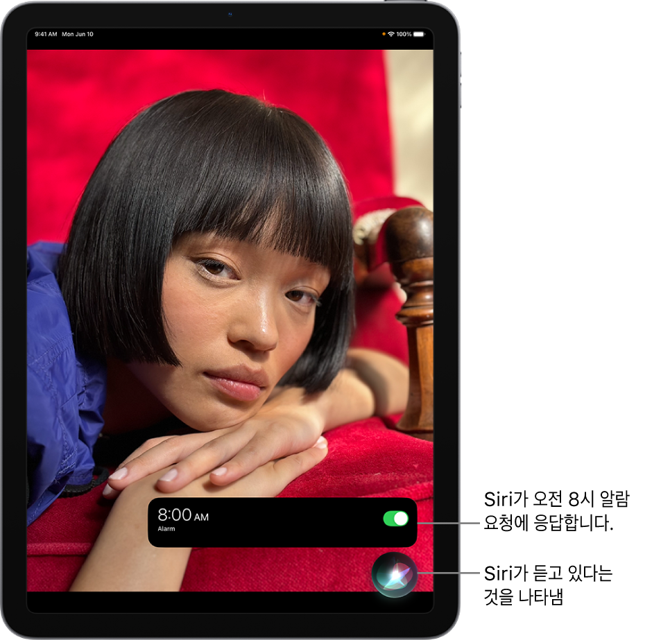 iPad 화면. 화면 하단 근처에 시계 앱의 알림이 오전 8시로 설정된 알람을 표시함. 알림 아래의 아이콘은 Siri가 듣고 있음을 나타냄.