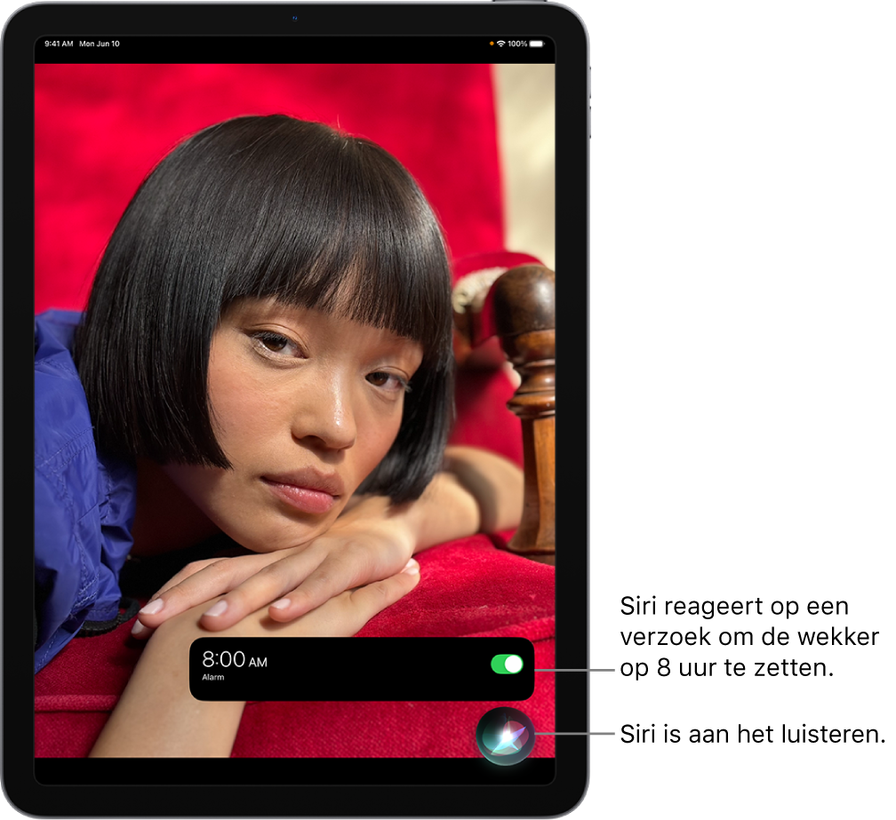 Een iPad-scherm. Onder in het scherm geeft een melding van de Klok-app aan dat een wekker voor 8 uur 's ochtends is ingeschakeld. Een symbool onder de melding geeft aan dat Siri luistert.