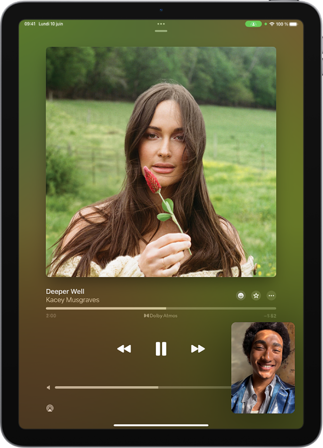 Un appel FaceTime affichant une session SharePlay avec un contenu Apple Music diffusé simultanément à tous les membres de l’appel. Une image de la personne à l’origine du partage apparaît en bas à droite. Une autre de l’album en cours de partage se trouve vers le haut de l’écran, et les commandes de lecture se trouvent en dessous de l’image de l’album.