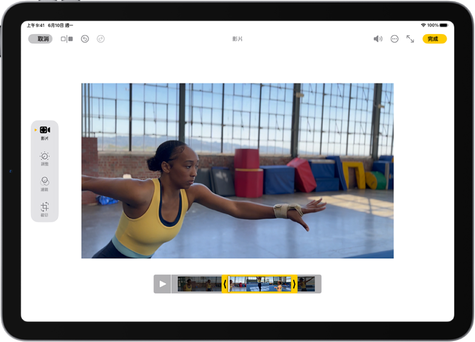 「照片」App 中的「編輯」畫面中央正在播放影片。影片的影格檢視器橫跨影片底部，要包含在裁剪影片中的所選影格周圍有黃色框線。螢幕左下方為「影片」、「調整」、「濾鏡」和「裁切」按鈕；已選取「影片」按鈕。