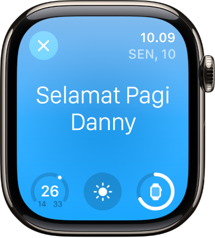 Apple Watch menampilkan layar bangun. Kata Selamat Pagi muncul di bagian atas. Suhu, kondisi cuaca, dan level baterai ada di bawah.