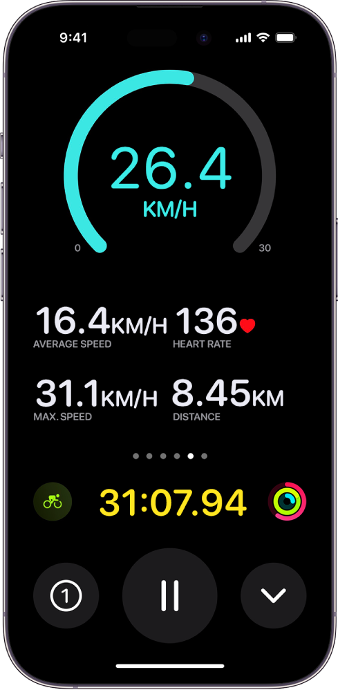 Notiekošs velotreniņš tiek parādīts iPhone tālrunī kā Live Activity; tajā redzams treniņa ātrums, vidējais ātrums, pulss, maksimālais ātrums, nobrauktais attālums un kopā pagājušais laiks.