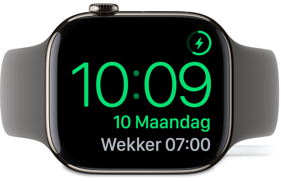 Een Apple Watch die op zijn kant ligt en is aangesloten op de oplader. Rechtsbovenin bevindt zich het oplaadsymbool en daaronder staan de actuele tijd en de tijd van de volgende wekker.