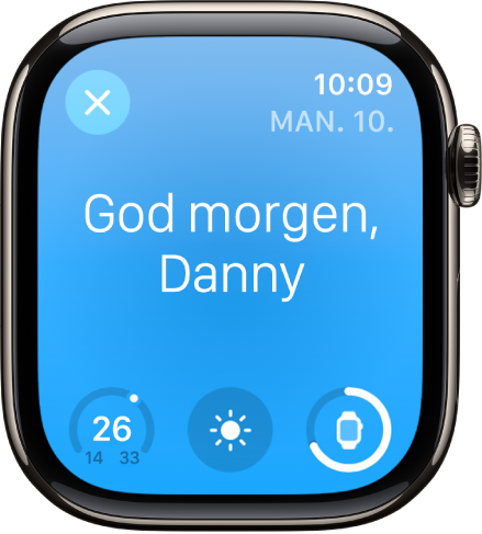 Apple Watch som viser oppvåkningsskjermen. Ordene God morgen vises øverst. Temperaturen, værforholdene og batterinivået er under.