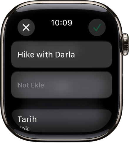 Apple Watch’taki Anımsatıcılar uygulamasında düzenleme ekranı. Anımsatıcının adı, altında bir açıklama ile en üst tarafta. Altında, anımsatıcının görünmesi için zamanlanan tarih var. Onay İşareti düğmesi sağ üstte. Kapat düğmesi sol üstte.