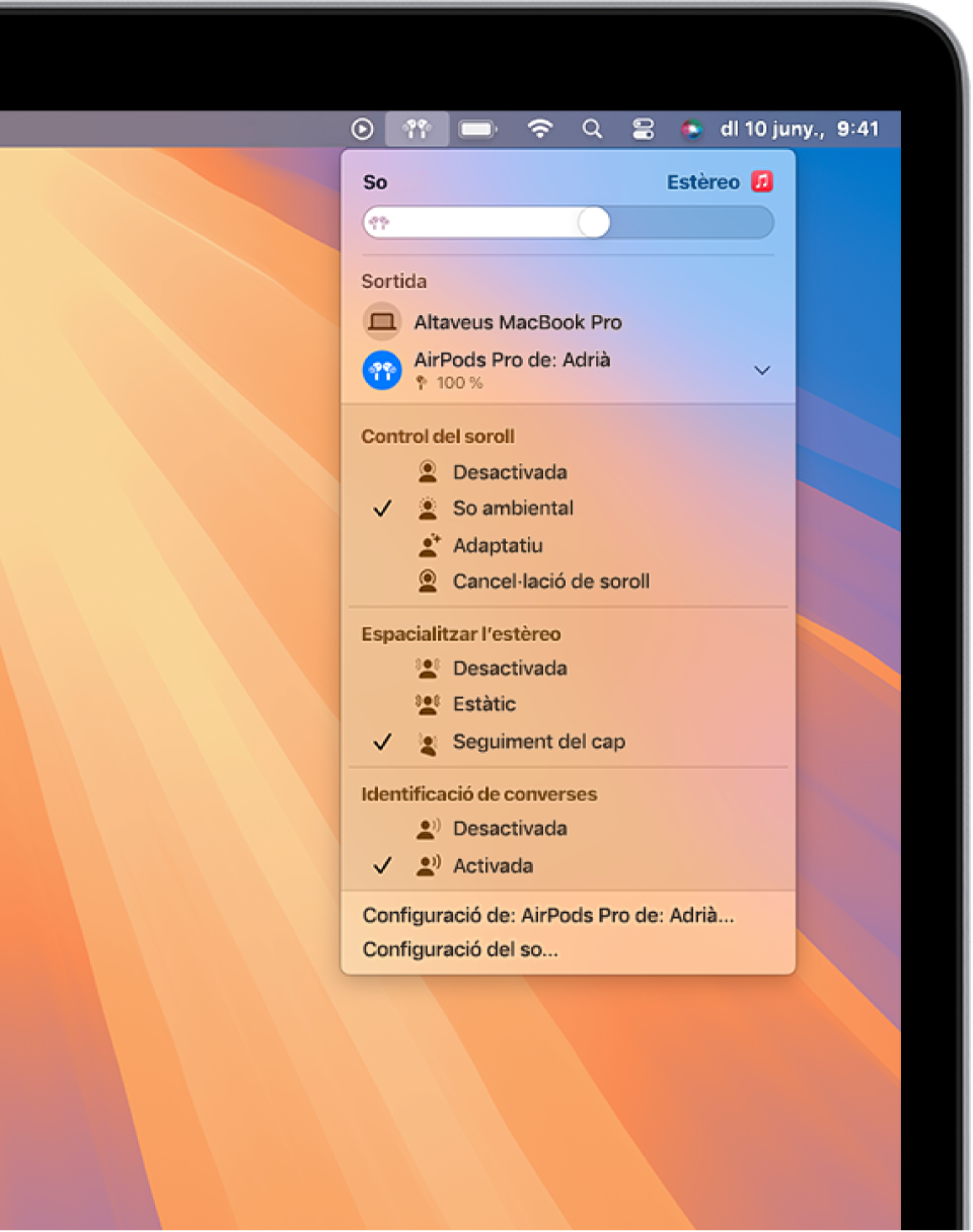Pantalla del MacBook Pro amb una cançó que s’està reproduint a l’app Música. A la barra de menús, la icona dels AirPods està seleccionada i un menú mostra els AirPods amb el mode de so ambiental i el seguiment del cap de l’àudio espacial activats.