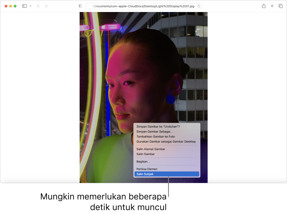 Gambar seseorang dengan lampu dan bangunan di latar belakang di Safari.