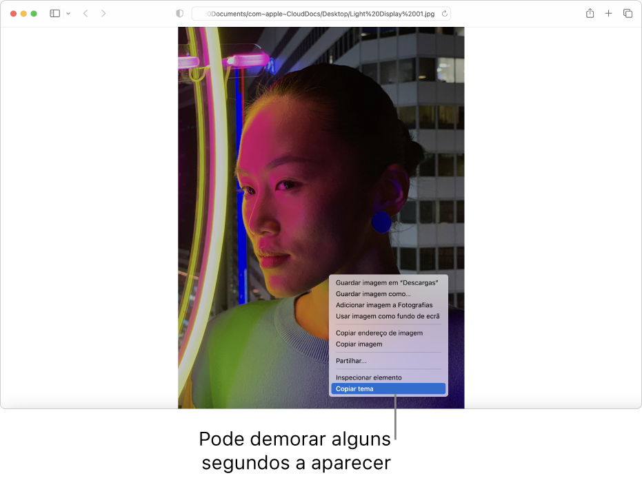 Uma imagem na aplicação Safari de uma pessoa com luzes e um edifício no fundo.