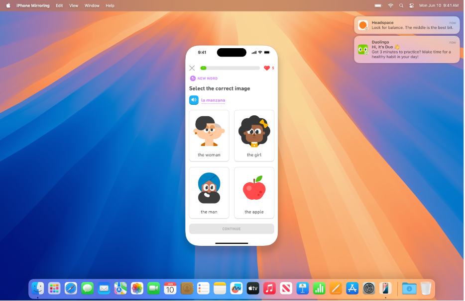 Plocha Macu s displejem iPhonu uprostřed a oznámeními z iPhonu v pravém horním rohu obrazovky