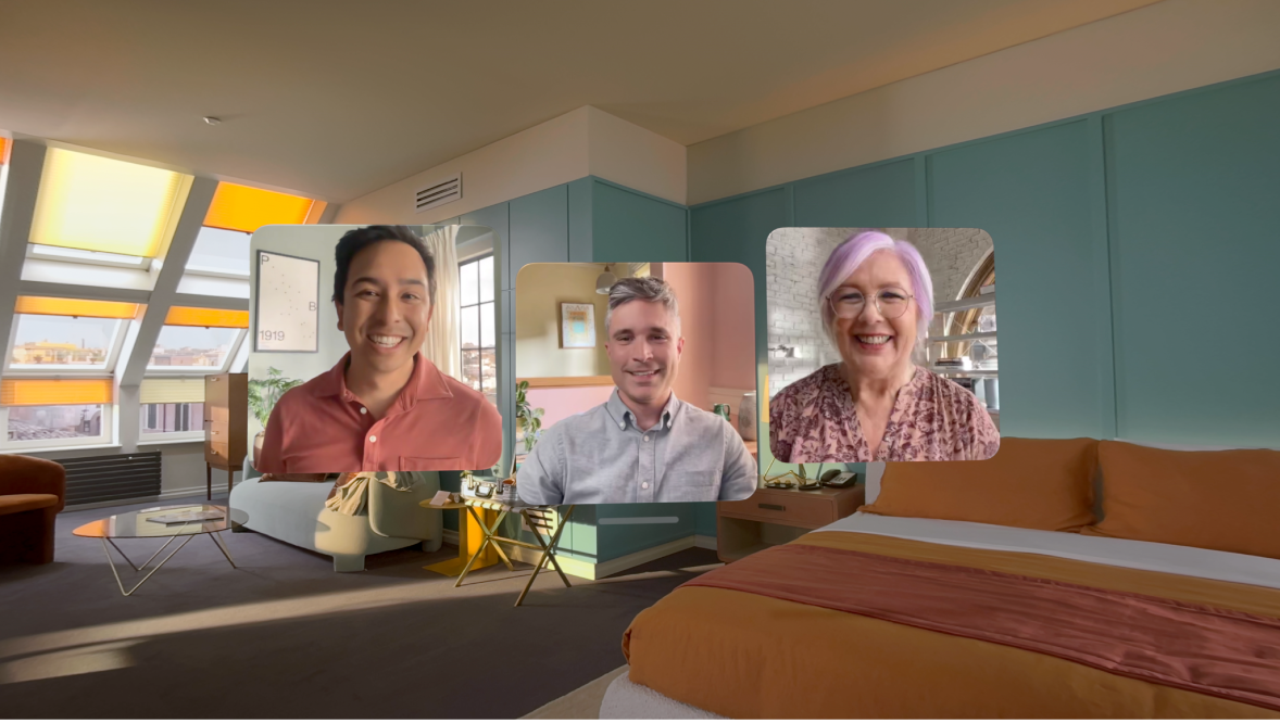 A FaceTime call on Apple Vision Pro, showing three tiles from other participants overlaying the user’s room.