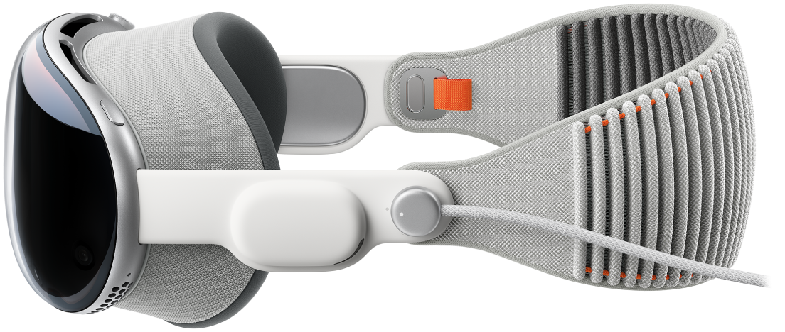Una vista laterale di Apple Vision Pro con la fascia Solo Knit agganciata. La batteria è collegata alla fascetta audio di sinistra.