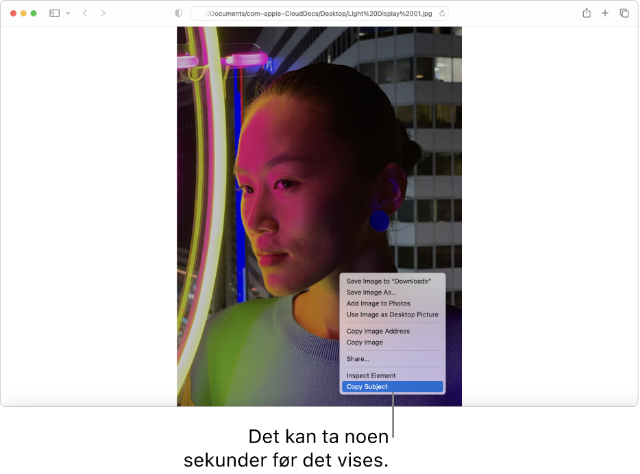 Et bilde i Safari av en person med lys og bygninger i bakgrunnen.