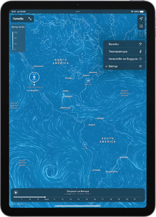 Карта на температурите на заобикалящата област запълва екрана на iPad. В горния десен ъгъл от горе надолу са бутоните Настоящо местоположение и Любими местоположения. Отворено е меню Препокриване и е избрано Вятър. В долния край има линия на времето. Бутонът за превключване към карта на цял екран и скалата на вятъра са в горния ляв ъгъл.