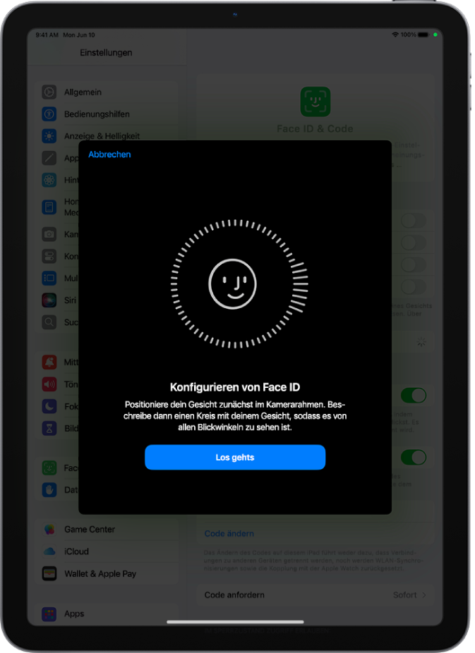 Der Konfigurationsbildschirm für die Face ID-Erkennung. Auf dem Bildschirm ist ein lächelndes Gesicht zu sehen, das von einem Kreis umgeben ist. Darunter weist Text den:die Benutzer:in an, den Kopf langsam zu bewegen, um den Kreis zu schließen. Unten auf dem Bildschirm wird eine Taste für „Los gehts“ angezeigt.
