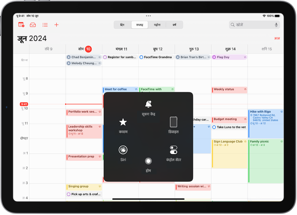 iPad जिसमें AssistiveTouch मेनू दृश्यमान है, सूचना केंद्र, डिवाइस, कंट्रोल सेंटर, होम, Siri और कस्टम के लिए कंट्रोल प्रदर्शित करता है।