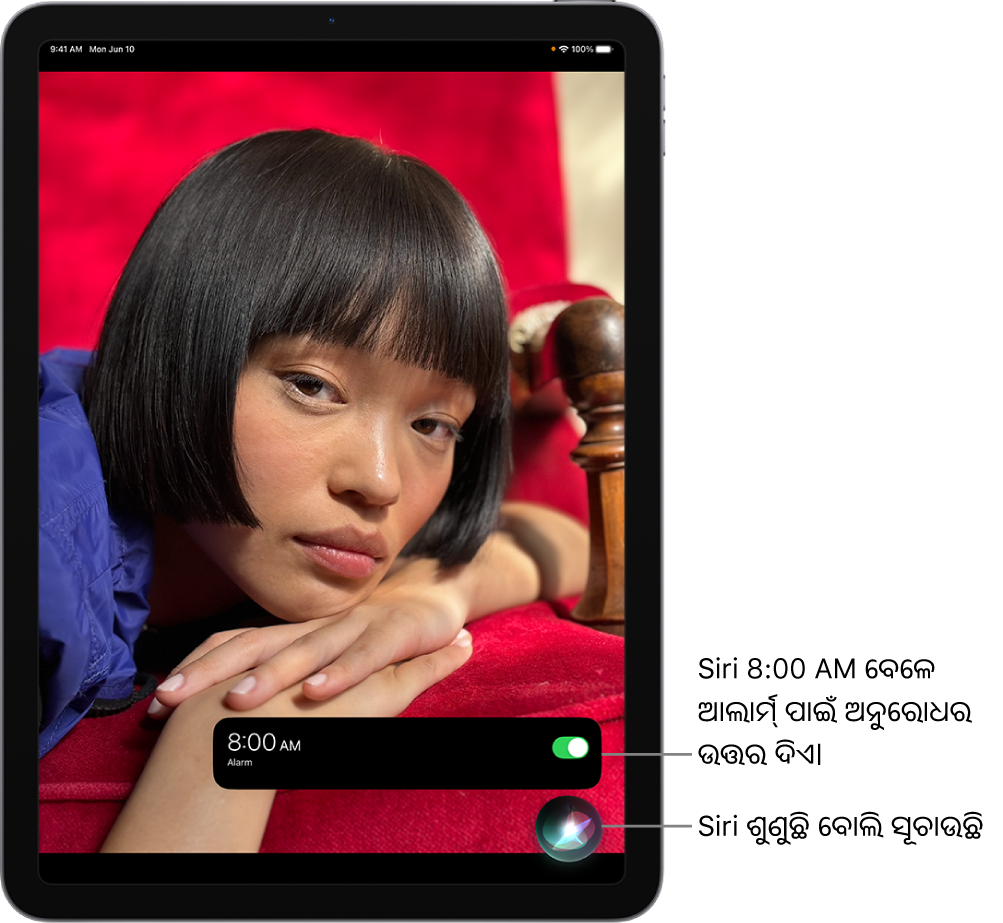 ଏକ iPad ସ୍କ୍ରୀନ୍। ସ୍କ୍ରୀନ୍‌ର ନିମ୍ନ ଭାଗ ନିକଟରେ, ଘଣ୍ଟା ଆପ୍‌ର ଏକ ନୋଟିଫିକେଶନ୍ ଦର୍ଶାଉଛି ଯେ, ସକାଳ 8.00 ପାଇଁ ଏକ ଆଲାର୍ମ୍ ଚାଲୁ ଅଛି। ନୋଟିଫିକେଶନ୍‌ର ନିମ୍ନରେ ଥିବା ଏକ ଆଇକନ୍ “Siri ଶୁଣୁଛି” ବୋଲି ଦର୍ଶାଉଛି।