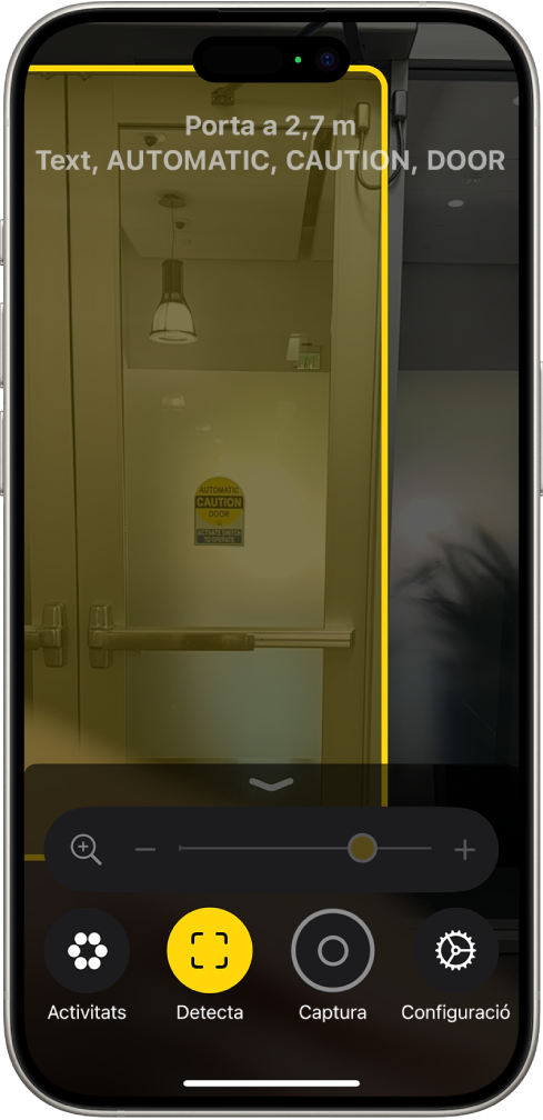 L’app Lupa està oberta i es detecta una porta. Una descripció mostra a quina distància està la porta i què diu el text de la porta.