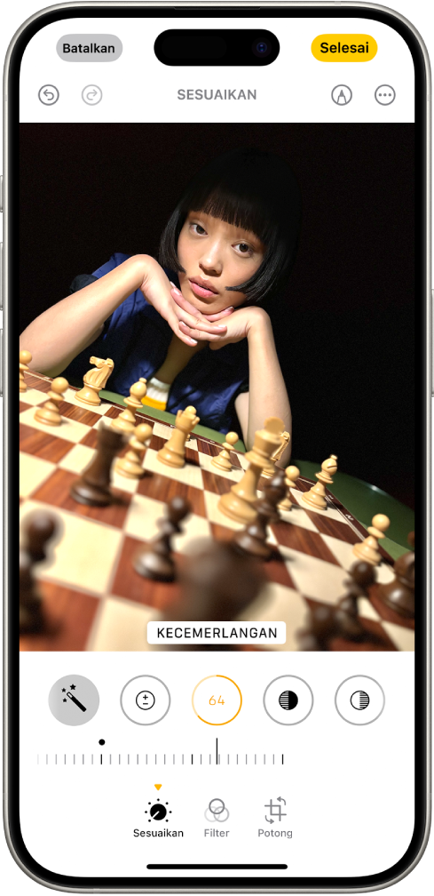 Layar Edit dengan foto di tengah. Di bagian bawah layar, dari kiri ke kanan, terdapat tombol Sesuaikan, Filter, dan Potong. Tombol Sesuaikan dipilih dan terdapat penggeser untuk menyesuaikan Kecerahan foto. Tombol Batalkan terdapat di pojok kiri atas layar dan tombol Selesai terdapat di pojok kanan atas layar.