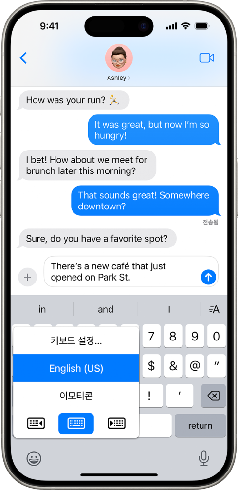 세 가지 옵션을 표시한 키보드 설정 메뉴가 열려 있음. 옵션은 영어(미국), 이모티콘, 키보드 피드백임. 메뉴 하단에는 왼쪽에서 오른쪽으로 왼손 입력 레이아웃, 기본 레이아웃 및 오른손 입력 레이아웃 버튼이 있음. 기본 레이아웃 버튼을 선택함.