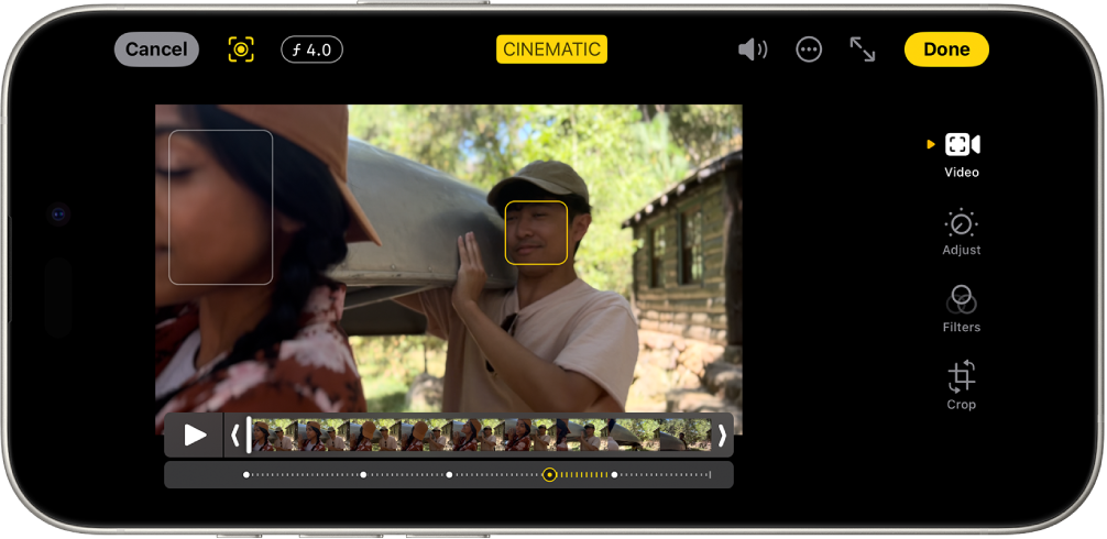 Režīmā Cinematic uzņemta video ekrāns Edit Ekrānā augšējā kreisajā pusē ir poga Cancel, poga Cinematic Manual un poga Depth Adjustment. Ekrāna augšdaļā pa vidu ir atlasīta poga Cinematic. Ekrāna augšdaļā pa labi ir poga Volume, poga More un poga Enter Full Screen, kā arī poga Done. Video atrodas ekrāna vidū, un ap fokusa objektu ir rāmis. Zem video ir kadru skatītājs, kas parāda punktu video, kurā mainās objekta fokuss. Rediģēšanas pogas atrodas ekrāna labajā pusē no augšas uz leju: Video, Adjust, Filters un Crop.