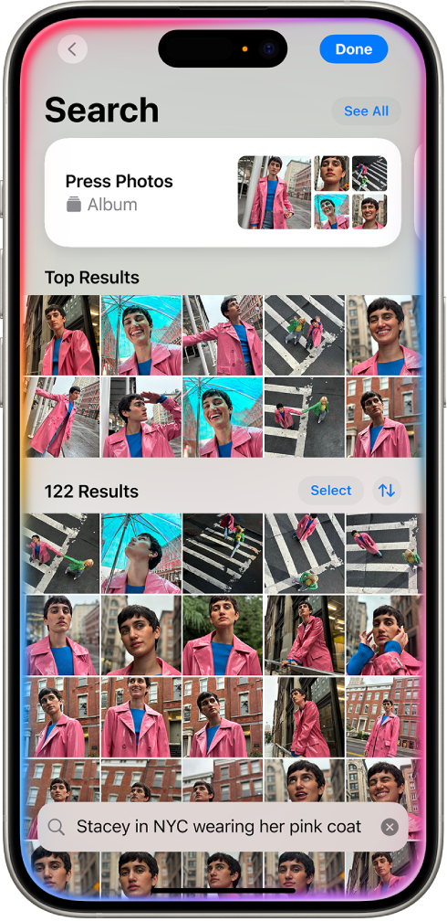 iPhone ഫോട്ടോസ് ആപ്പിൽ ഫോട്ടോകൾ കാണിക്കുന്നു. ഒരു വിവരണമുള്ള ഒരു തിരയൽ ബാർ സ്ക്രീനിന്റെ താഴെ ദൃശ്യമാകുന്നു.