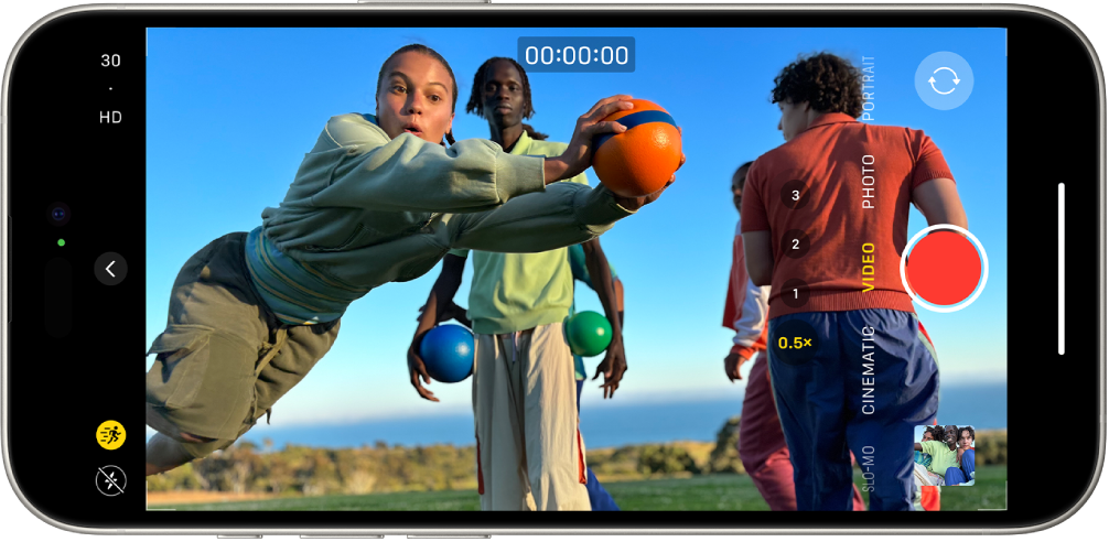 iPhone ကို အလျားလိုက်ထားပါ။ Camera ကို ဖွင့်၍ Video မုဒ်တွင်ထားပါ။ ကင်မရာဘောင်အတွင်းမှာ လူတစ်ယောက်သည် ရွရွပြေးနေသည်။ ဖန်သားပြင်၏ ဘယ်ဘက်အောက်ခြေထောင့်တွင် Flash ခလုတ်ရှိသည်။ ဖန်သားပြင်၏ ဘယ်ဘက်အလယ်တွင် Camera Controls ခလုတ်ရှိသည်။ ဘယ်ဘက်ထိပ်ထောင့်တွင် ဗီဒီယိုရုပ်ထွက်အရည်အသွေးကိုပြောင်းရန် အမြန်အလွယ်သုံးလွှဲခလုတ်များရှိသည်။ ဘယ်ဘက်ထိပ်ဆုံးထောင့်မှ Action ခလုတ်သည်ပွင့်နေမည်ဖြစ်သည်။ ဖန်သားပြင်၏ညာဘက်ခြမ်းရှိ အထက်မှအောက်ခြေတစ်လျှောက်တွင် Camera Chooser Back-Facing ခလုတ်၊ ၊ Record ခလုတ် နှင့် Photo နှင့် Video Viewer ခလုတ်တို့ရှိသည်။ ကင်မရာရိုက်ကွက်ပြကိရိယာအတွင်း လူတစ်ဦး ပြေးနေသည်။