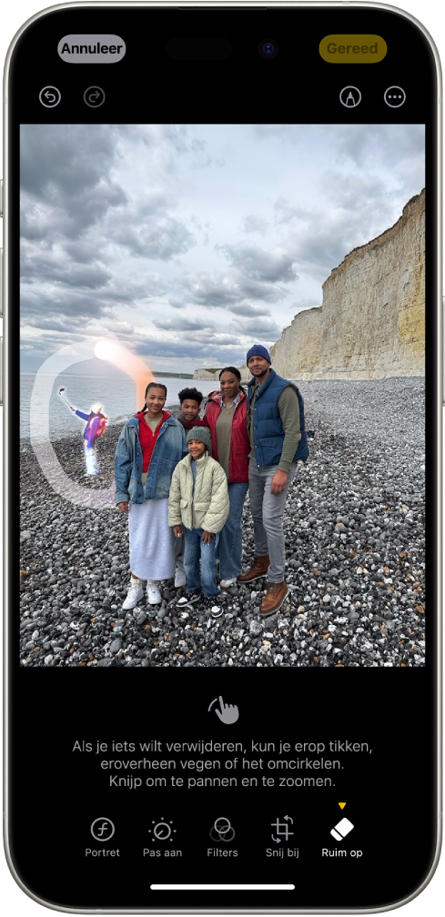 Een iPhone met een bewerkte foto in de Foto's-app. Een figuur op de achtergrond van de foto is gemarkeerd met een cirkel eromheen.