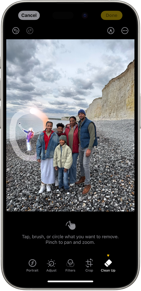 На iPhone-у је приказана уређена фотографија у апликацији Photos. Фигура у позадини фотографије је истакнута тако што је заокружена.